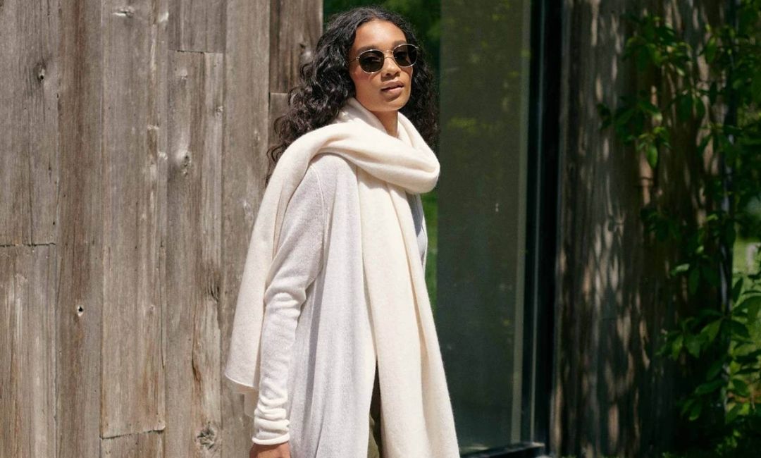 woman wearing a white + warren white cashmere travel wrap available at carriage house